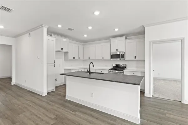 a kitchen with stainless steel appliances kitchen island granite countertop a sink and cabinets