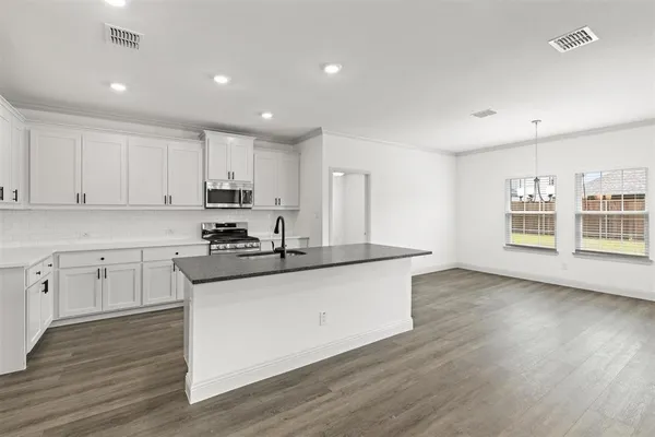 a kitchen with granite countertop a sink and cabinets