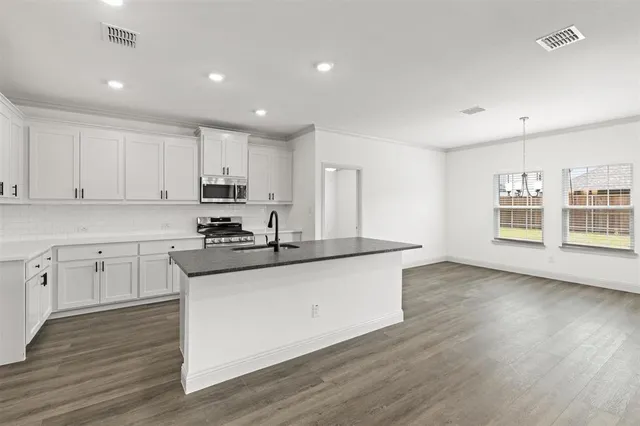 a kitchen with granite countertop a sink and cabinets