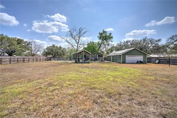 an empty room with wooden floor chandelier and windows
