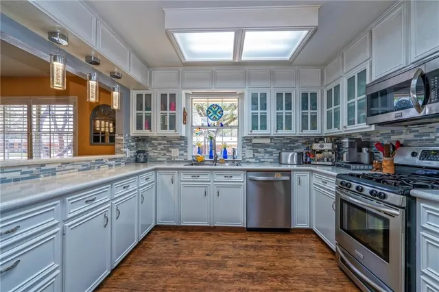 a kitchen with stainless steel appliances granite countertop a stove sink and cabinets