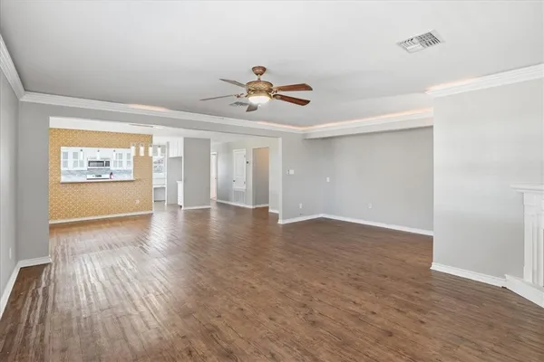 a view of empty room with wooden floor and fireplace