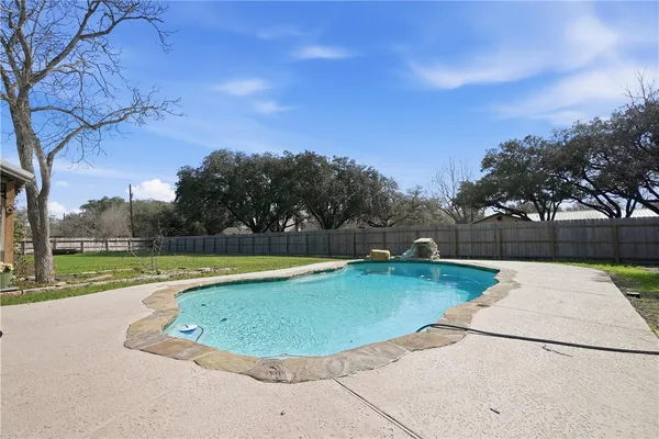 an empty room with wooden floor cabinet and windows