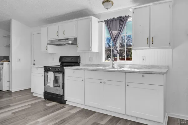 a kitchen with white cabinets and appliances