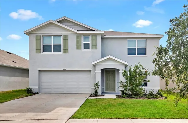 a front view of a house with a yard and garage