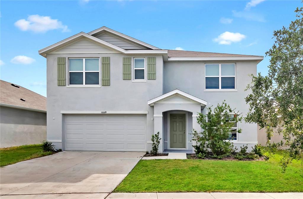 a front view of a house with a yard and garage