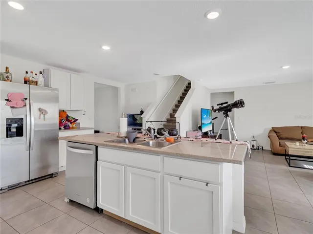 a kitchen with stainless steel appliances granite countertop a sink a stove a refrigerator a microwave oven with a dining table and chairs