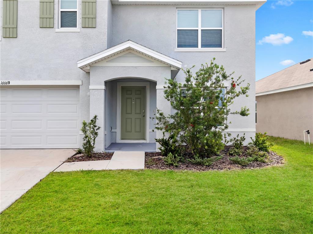 16669 Windmill Forge Pass Wimauma, FL 33598 - Photo 2 of 44 a front view of a house with a garden
