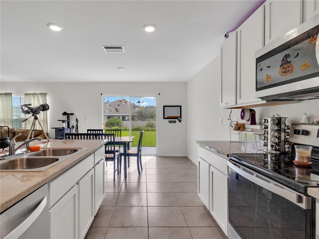 16669 Windmill Forge Pass Wimauma, FL 33598 - Photo 10 of 44 a kitchen with stainless steel appliances granite countertop a sink and a refrigerator