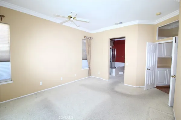 a view of an empty room with closet and a window