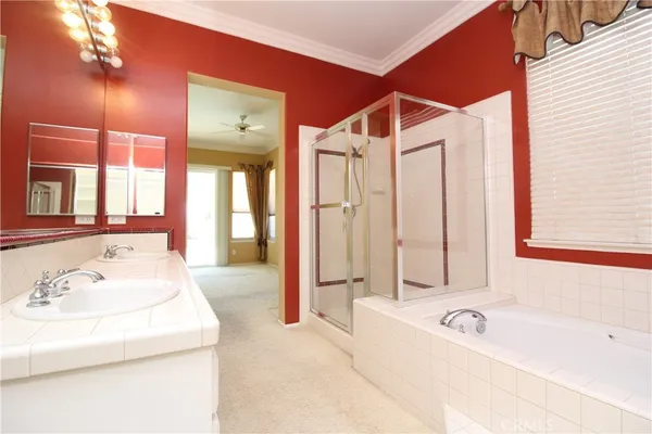 a bathroom with a tub a sink and a large mirror