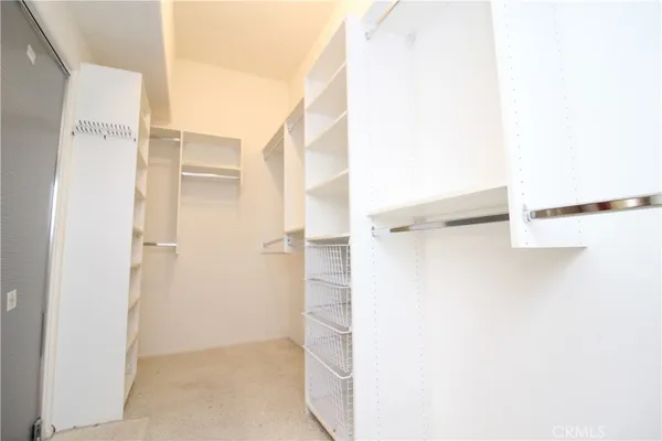 a view of walk in closet with empty racks
