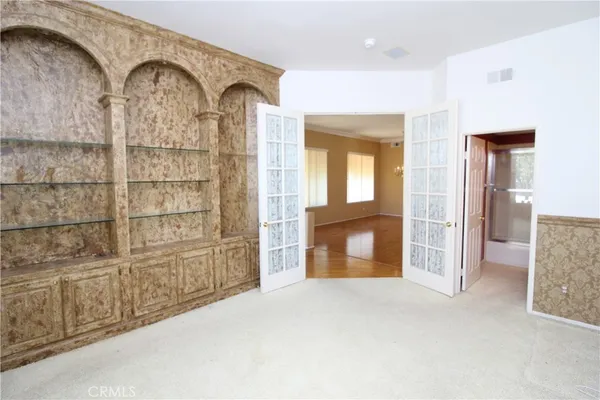 an empty room with cabinet and mirrors