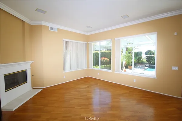 a view of an empty room with a window and a kitchen
