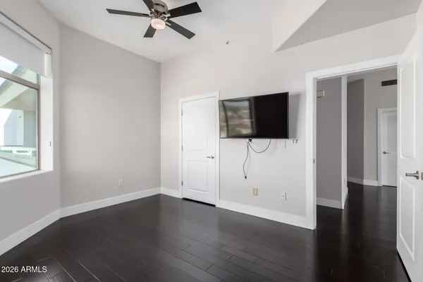 an empty room with wooden floor and windows
