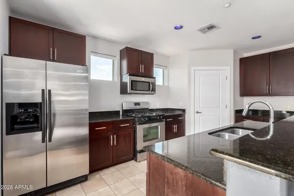 a kitchen with stainless steel appliances granite countertop a sink stove and refrigerator