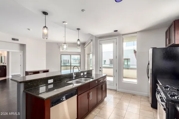 a kitchen with granite countertop a sink stove and refrigerator