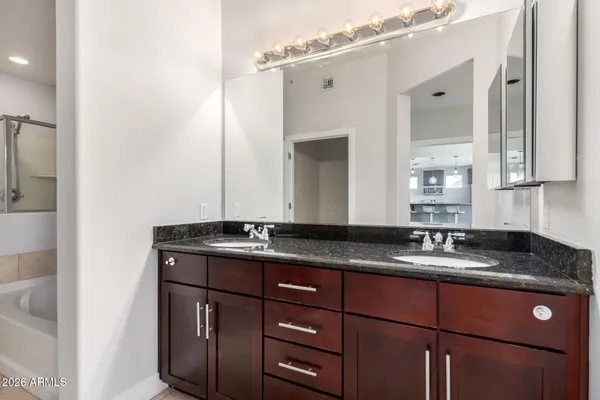 a bathroom with a granite countertop sink and a mirror