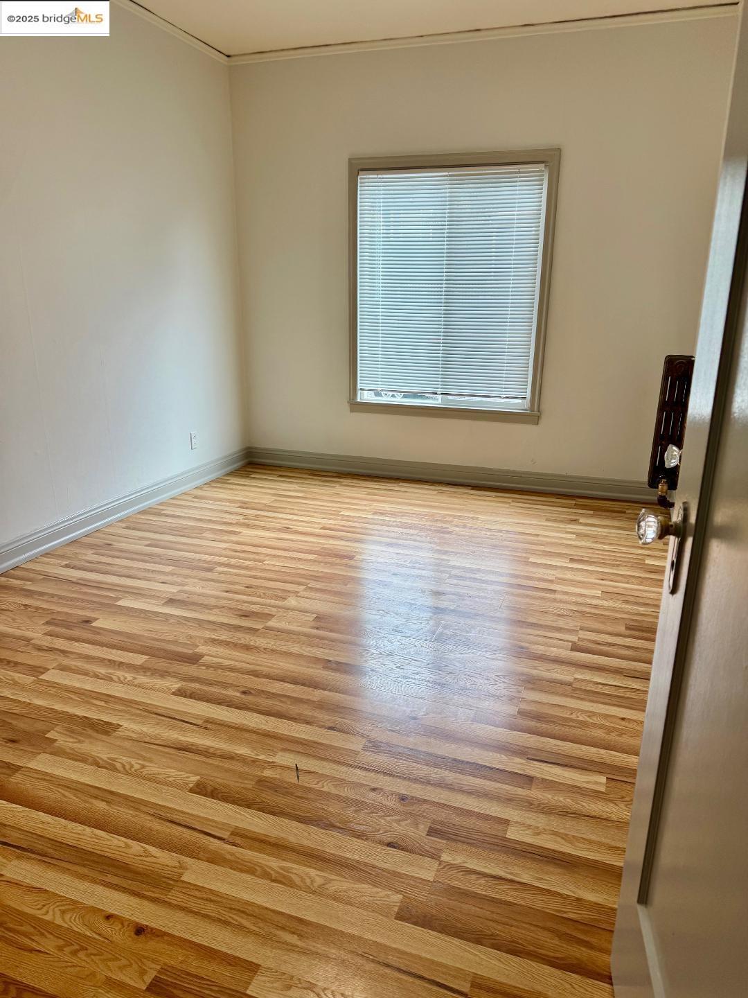 2240 MacArthur Boulevard Oakland, CA 94602 - Photo 5 of 13 Spare room with wood finished floors and crown molding
