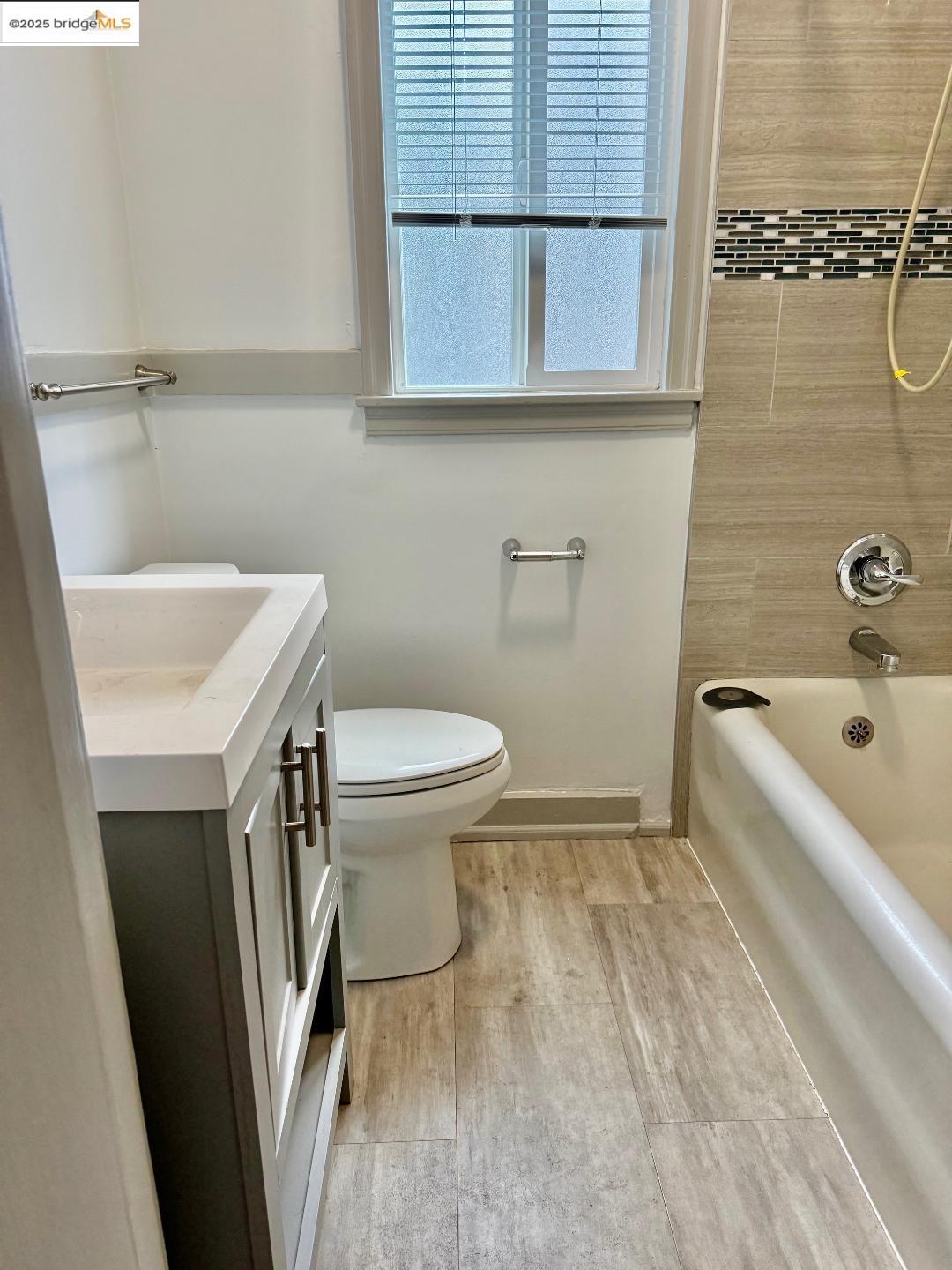 2240 MacArthur Boulevard Oakland, CA 94602 - Photo 6 of 13 Bathroom featuring vanity, washtub / shower combination, and wood finished floors