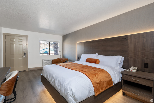 245 Red Cliffs Drive, Unit 104 St. George, UT 84790 - Photo 8 of 33 Bedroom featuring light wood finished floors and a textured ceiling