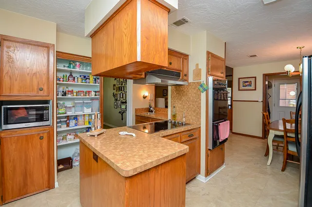 a kitchen with stainless steel appliances kitchen island granite countertop a table and chairs in it