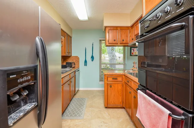a kitchen with stainless steel appliances granite countertop a refrigerator and a stove top oven