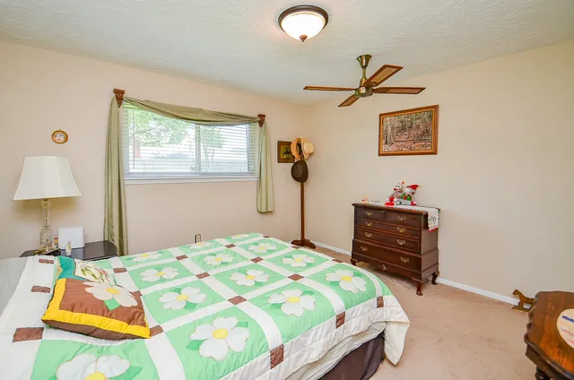 a bedroom with a bed and a lamp on dresser