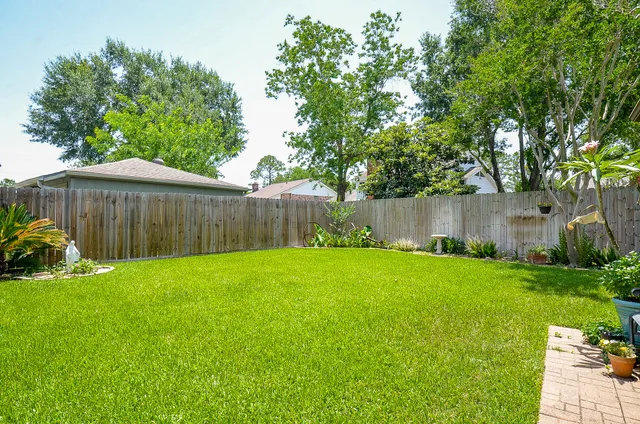 a view of a backyard with a garden and deck