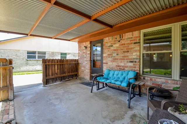 a backyard of a house with barbeque oven table and chairs