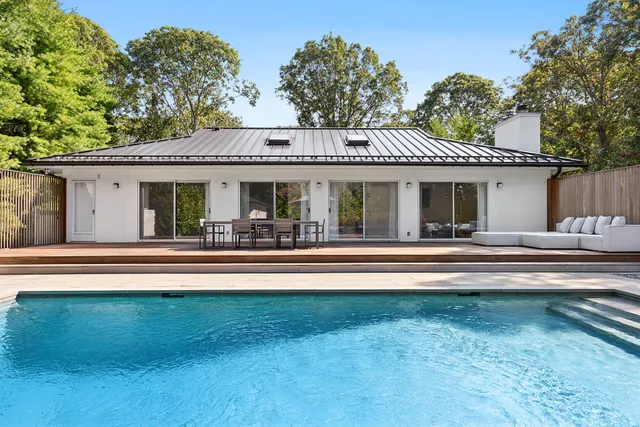 a view of house with a yard and a large tree