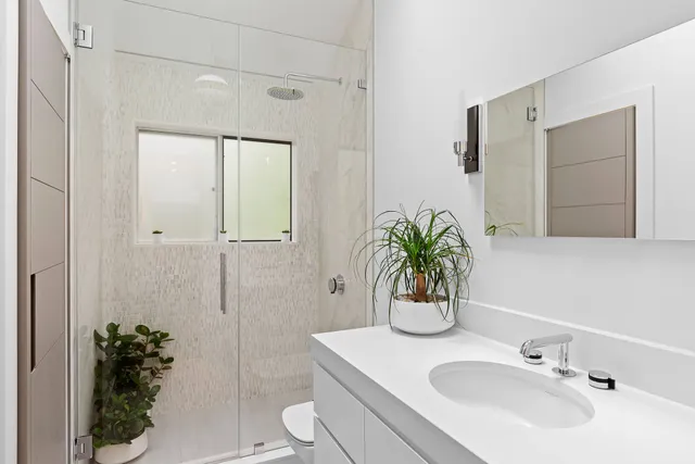 a bathroom with a sink a toilet and shower