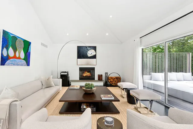 a living room with furniture fireplace and a large window