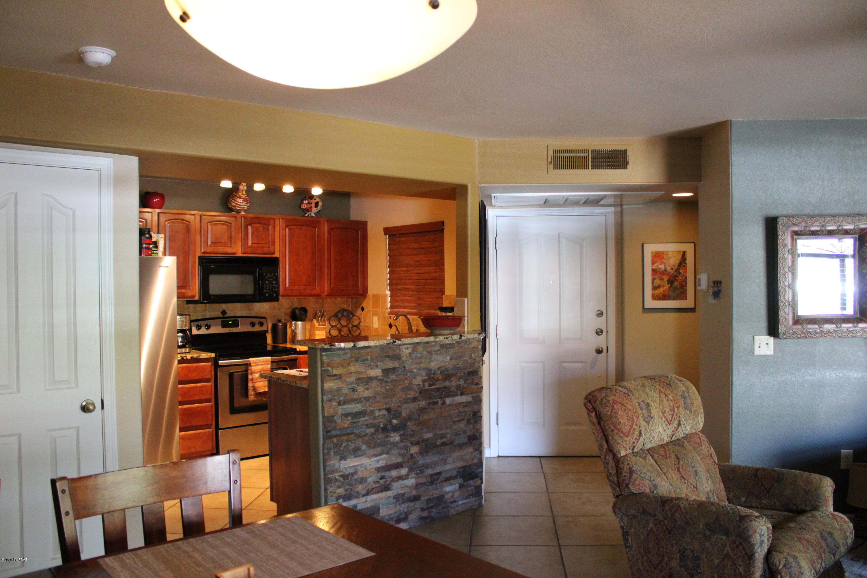 5751 North Kolb Road, Unit 36203 Tucson, AZ 85750 - Photo 10 of 25 a living room with furniture a flat screen tv and kitchen view