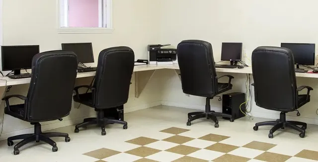 a view of a workspace with furniture and a window