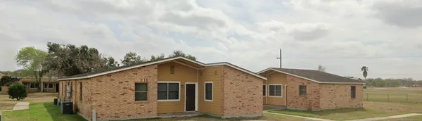 a view of a big house with wooden fence