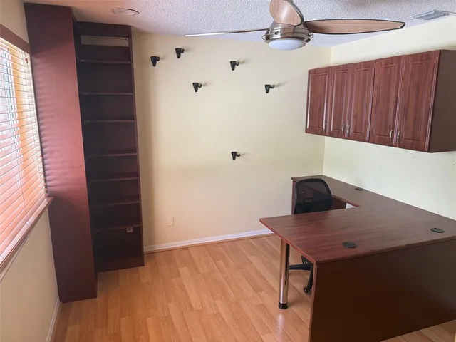 a view of a kitchen with a fridge and wooden floor