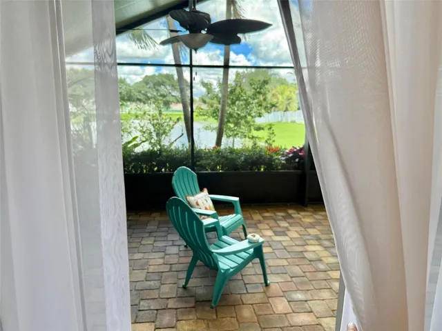 a living room with chairs and a floor to ceiling window