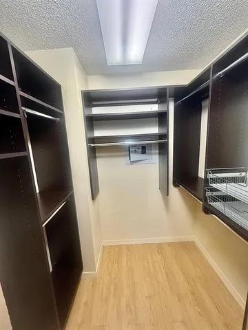a view of walk in closet with empty racks