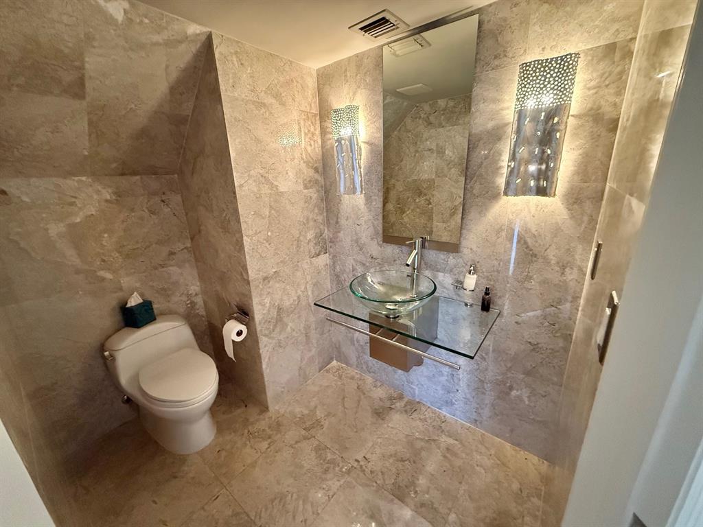 1654 Southwest 109th Terrace Davie, FL 33324 - Photo 8 of 24 a bathroom with a granite countertop sink a toilet and a mirror