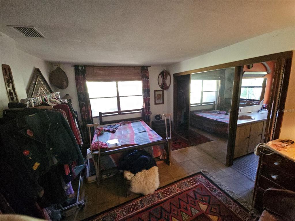 10679 Goose Prairie Road Leesburg, FL 34788 - Photo 20 of 30 a living room with furniture a rug and a floor to ceiling window