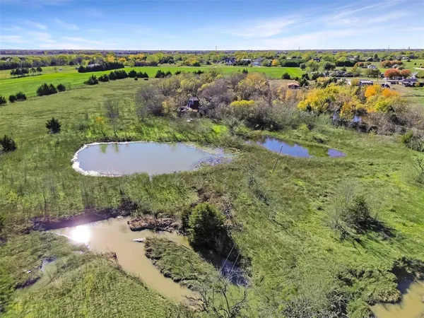 an aerial view of a house with a yard and lake view
