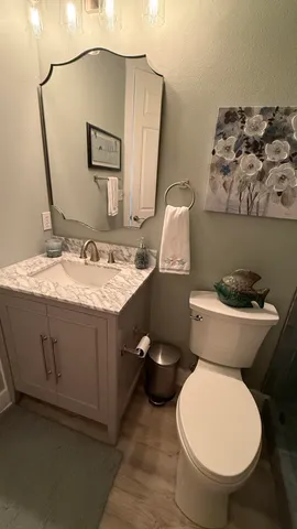 a bathroom with a sink vanity mirror and toilet