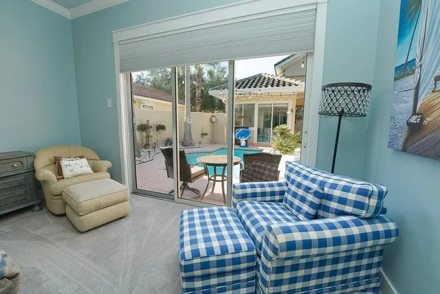 a view of a house with patio furniture and floor to ceiling windows