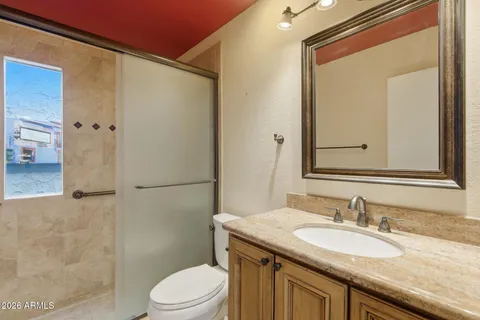 a bathroom with a granite countertop sink toilet and shower
