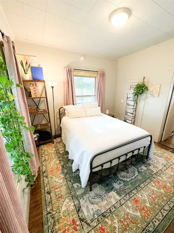 a bedroom with a bed table and a window