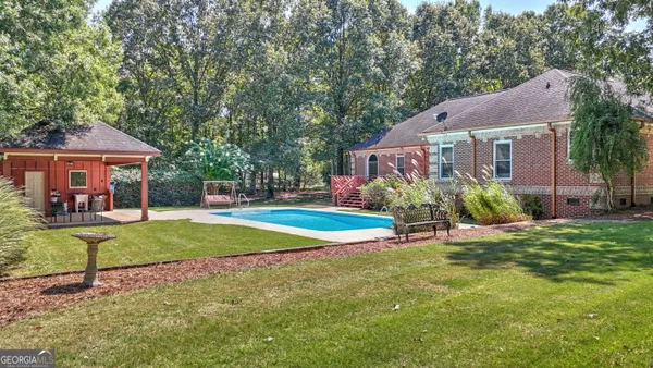 a view of a house with a big yard and large tree