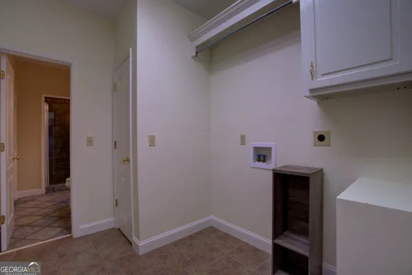 an empty room with a window and a chandelier