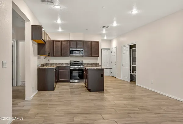 a kitchen with granite countertop sink stove and cabinets