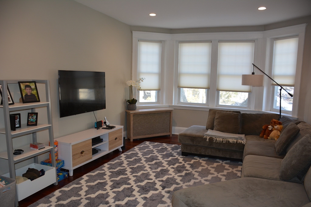 54 Dwight Street, Unit 3 Brookline, MA 02446 - Photo 3 of 16 a living room with furniture and a flat screen tv